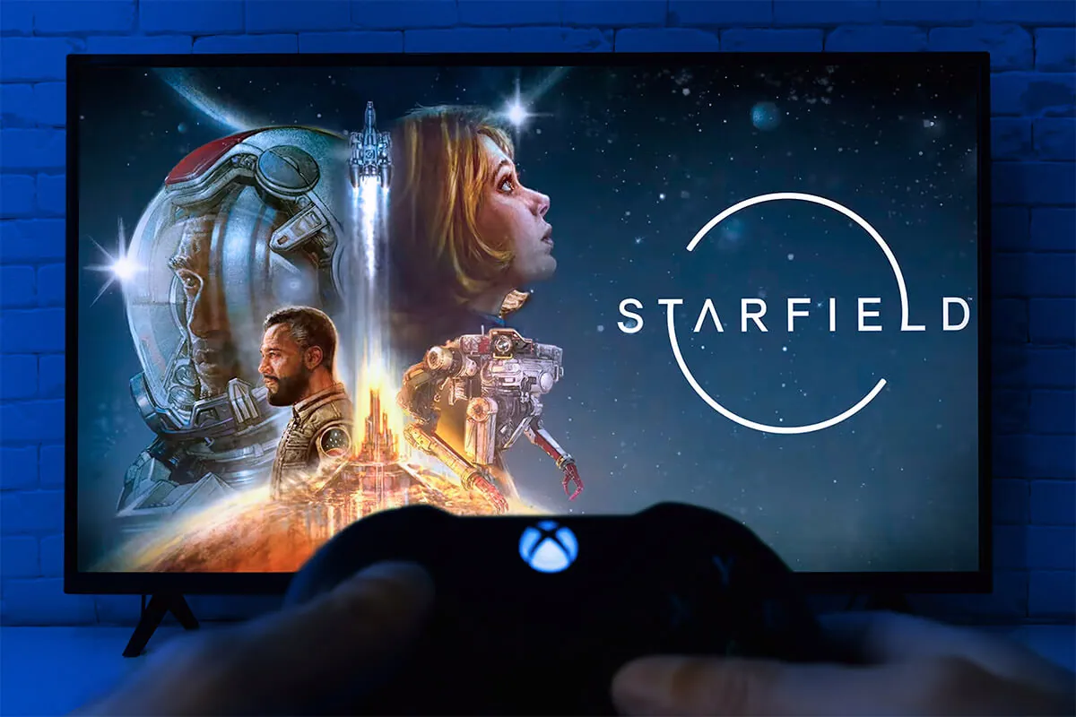 Man Playing Starfield game in front of TV with Xbox controller,