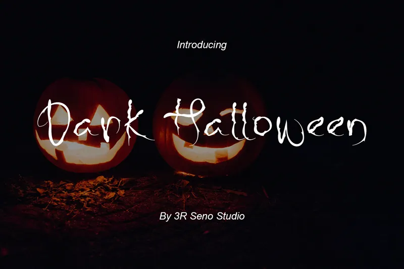Two glowing jack-o'-lanterns illuminate the "Dark Halloween" text, crafted with a free Halloween font, against a shadowy backdrop.